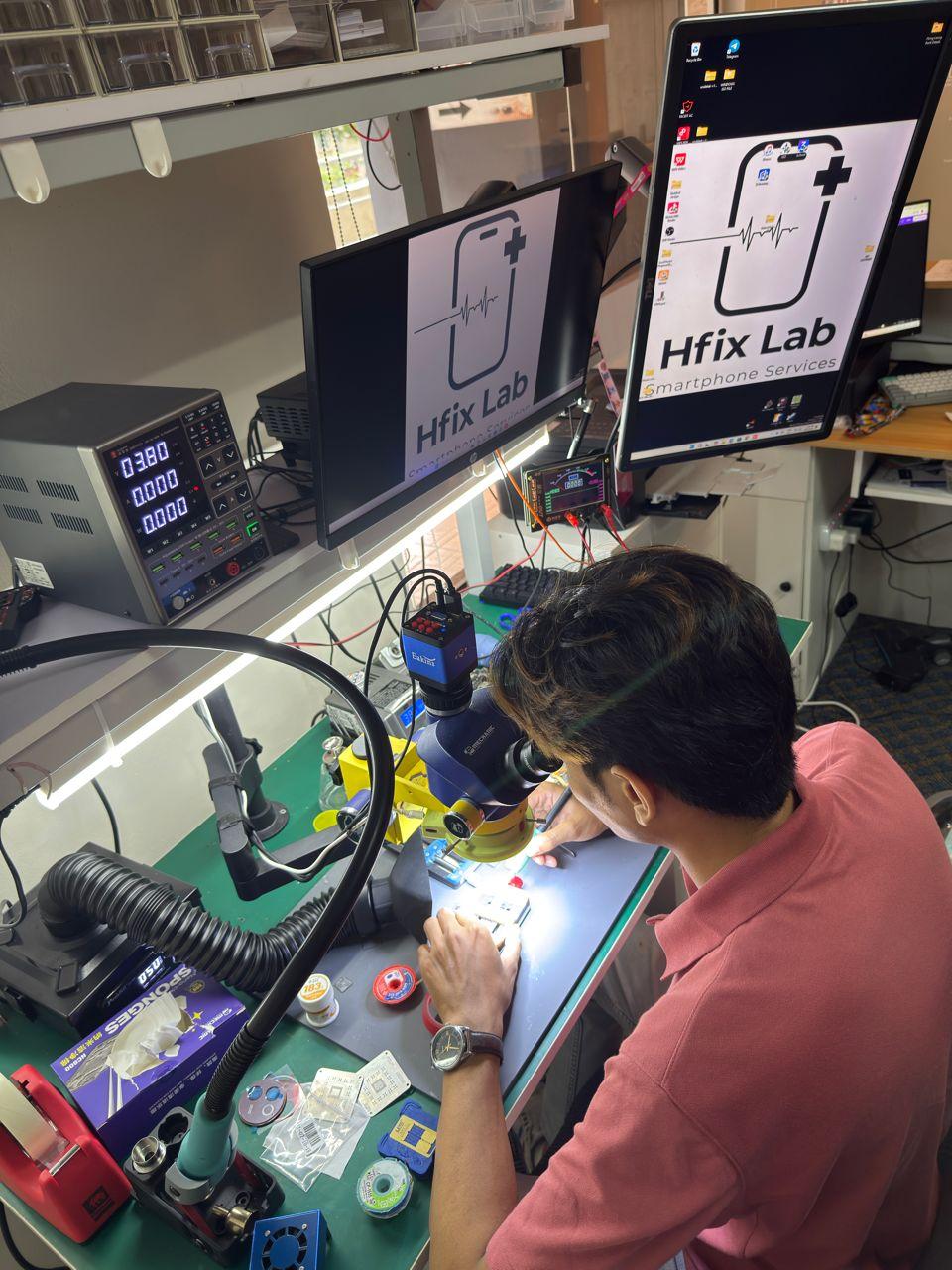Hfix Lab technician repairing a smartphone under microscope